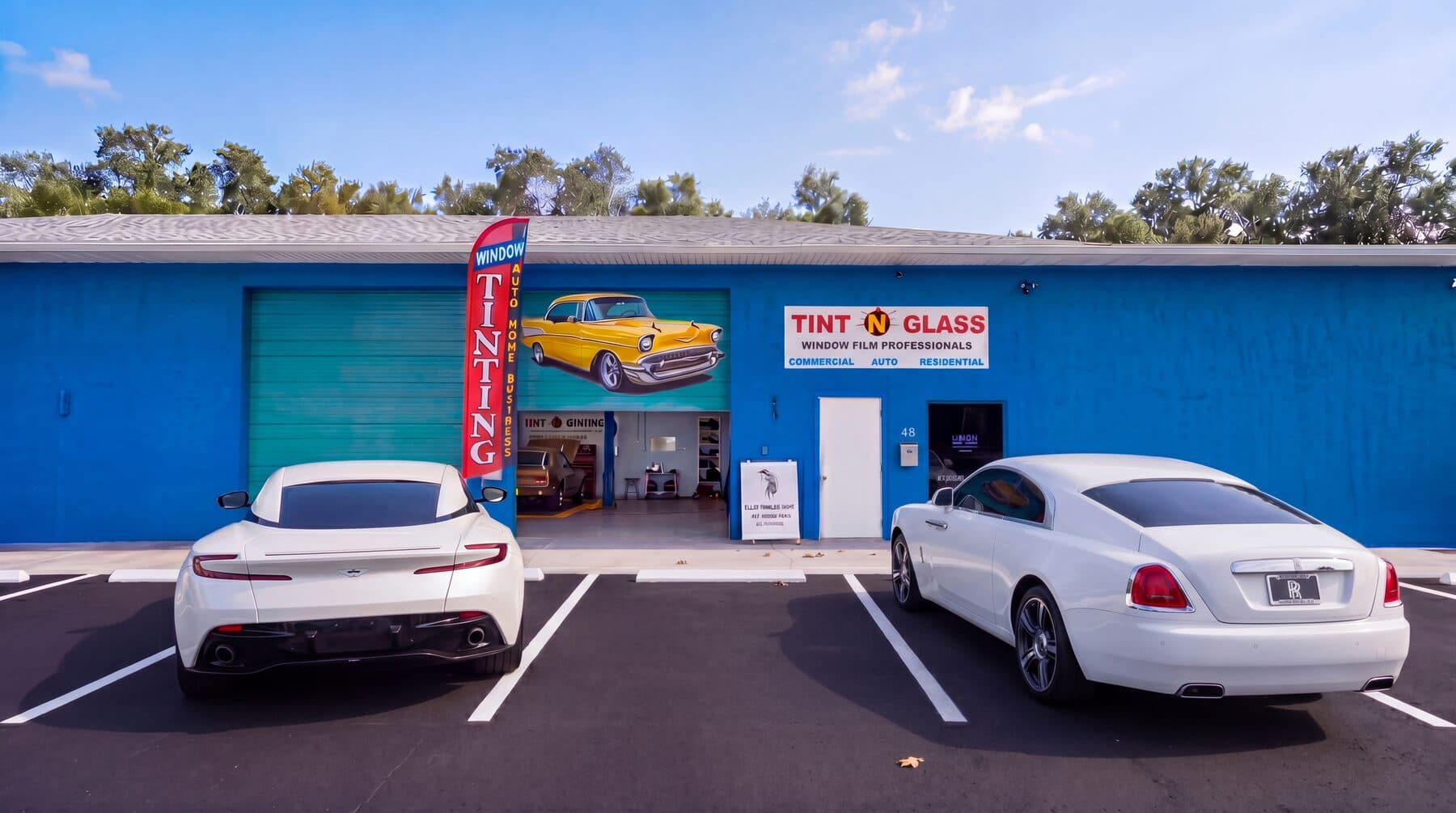 Tint N Glass storefront with customer vehicles parked out front.
