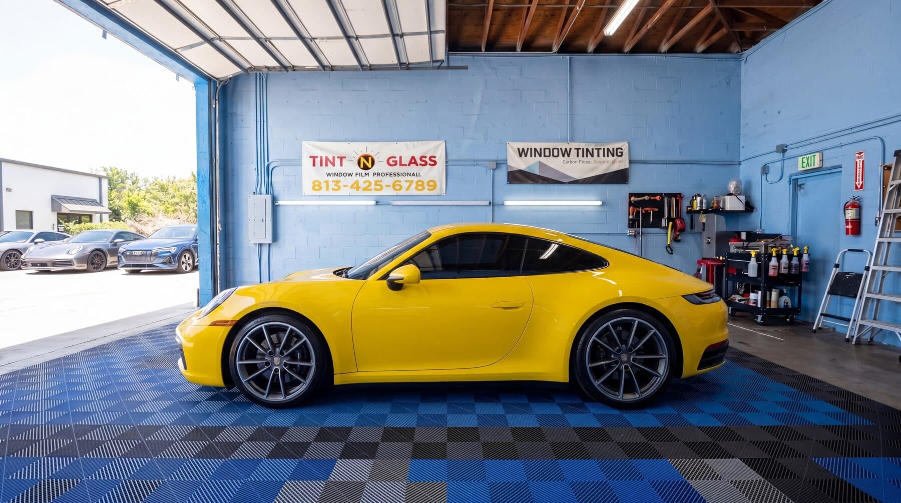 Yellow Porsche inside the Tint N Glass shop